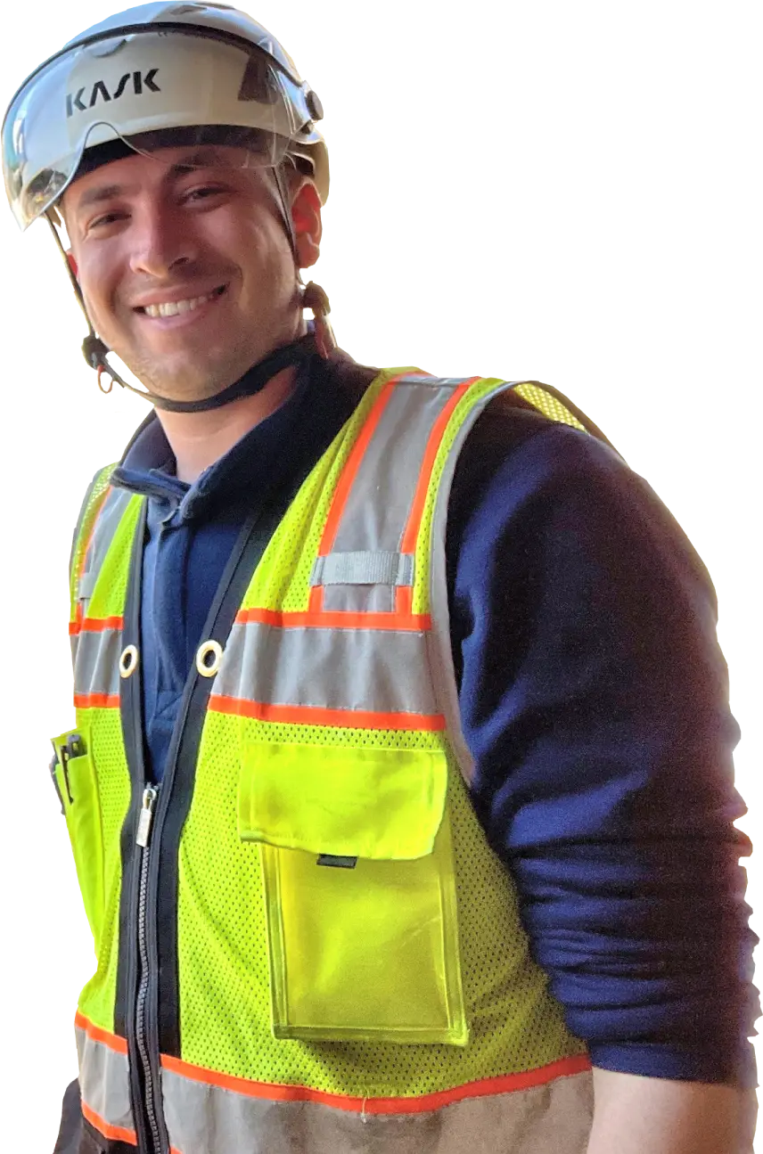 A man in safety vest and hard hat smiling.